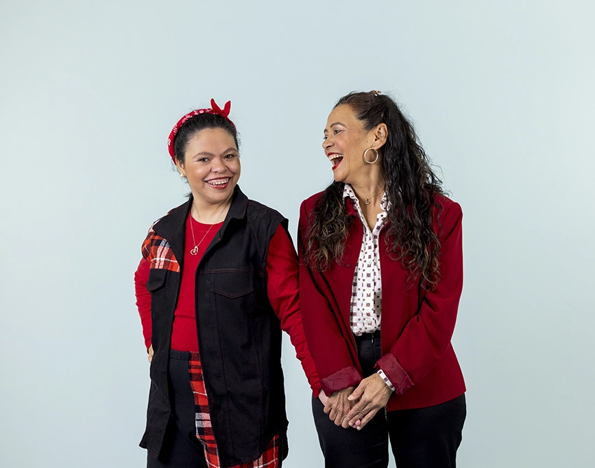 Two women holding hands laughing