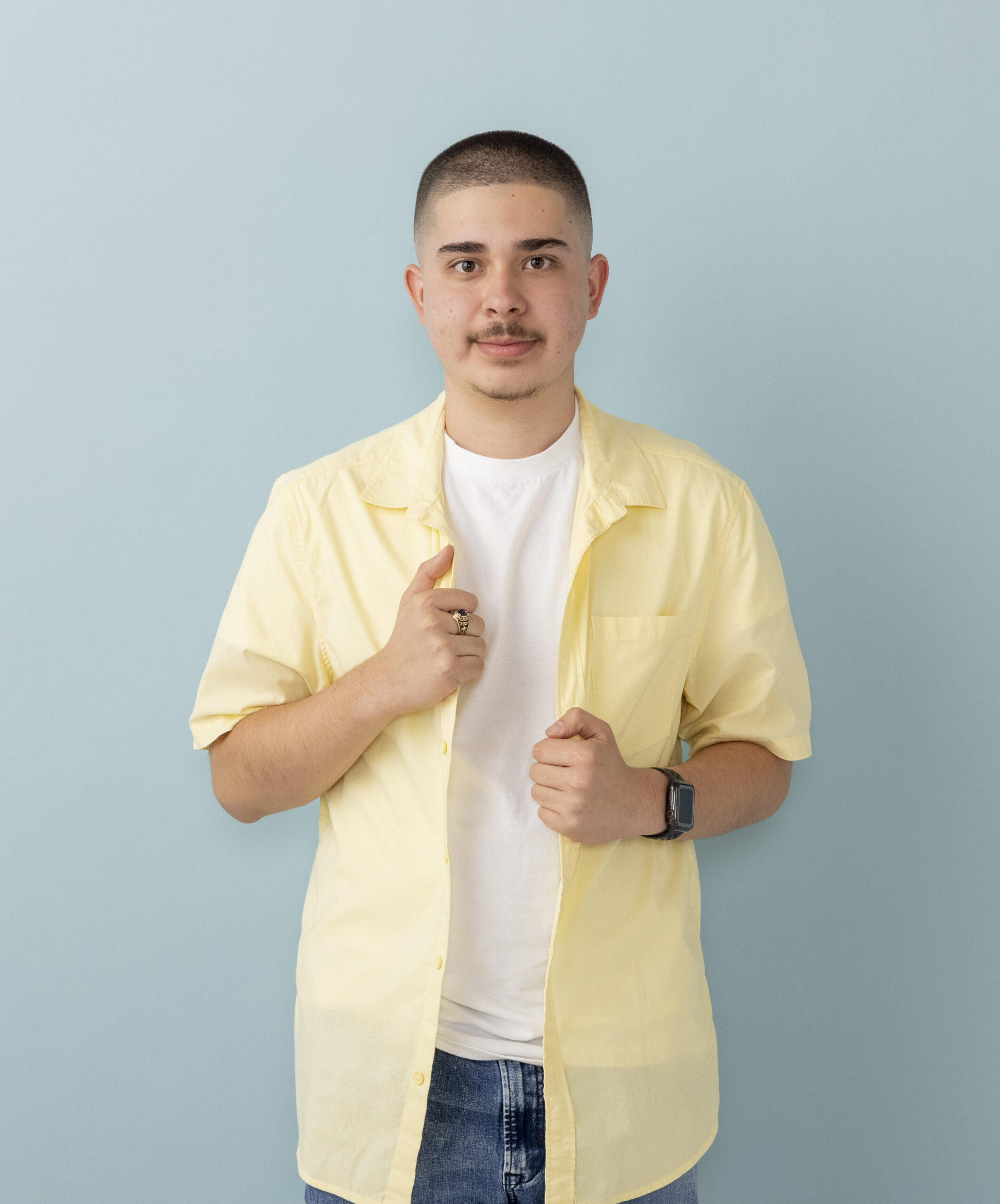 A guy in a yellow shirt smiling at the camera