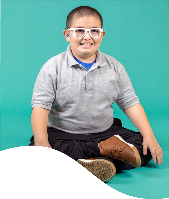 A autistic boy sitting smiling