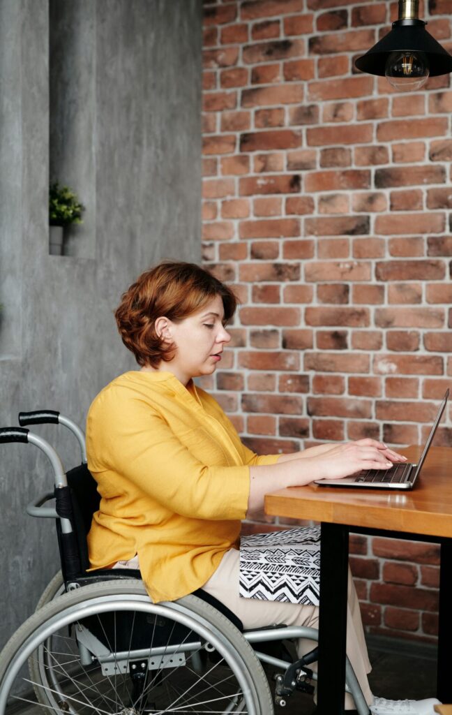 A woman in a wheelchair working on her laptop