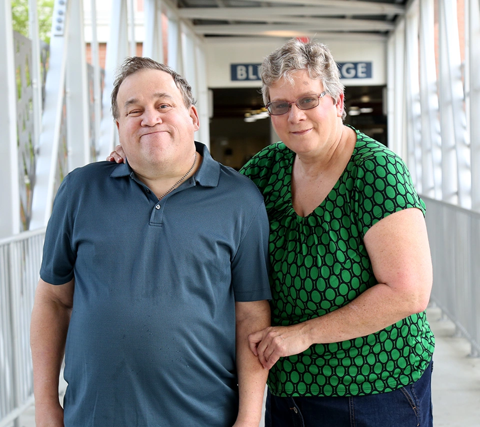 A Lady with an autistic man smiling